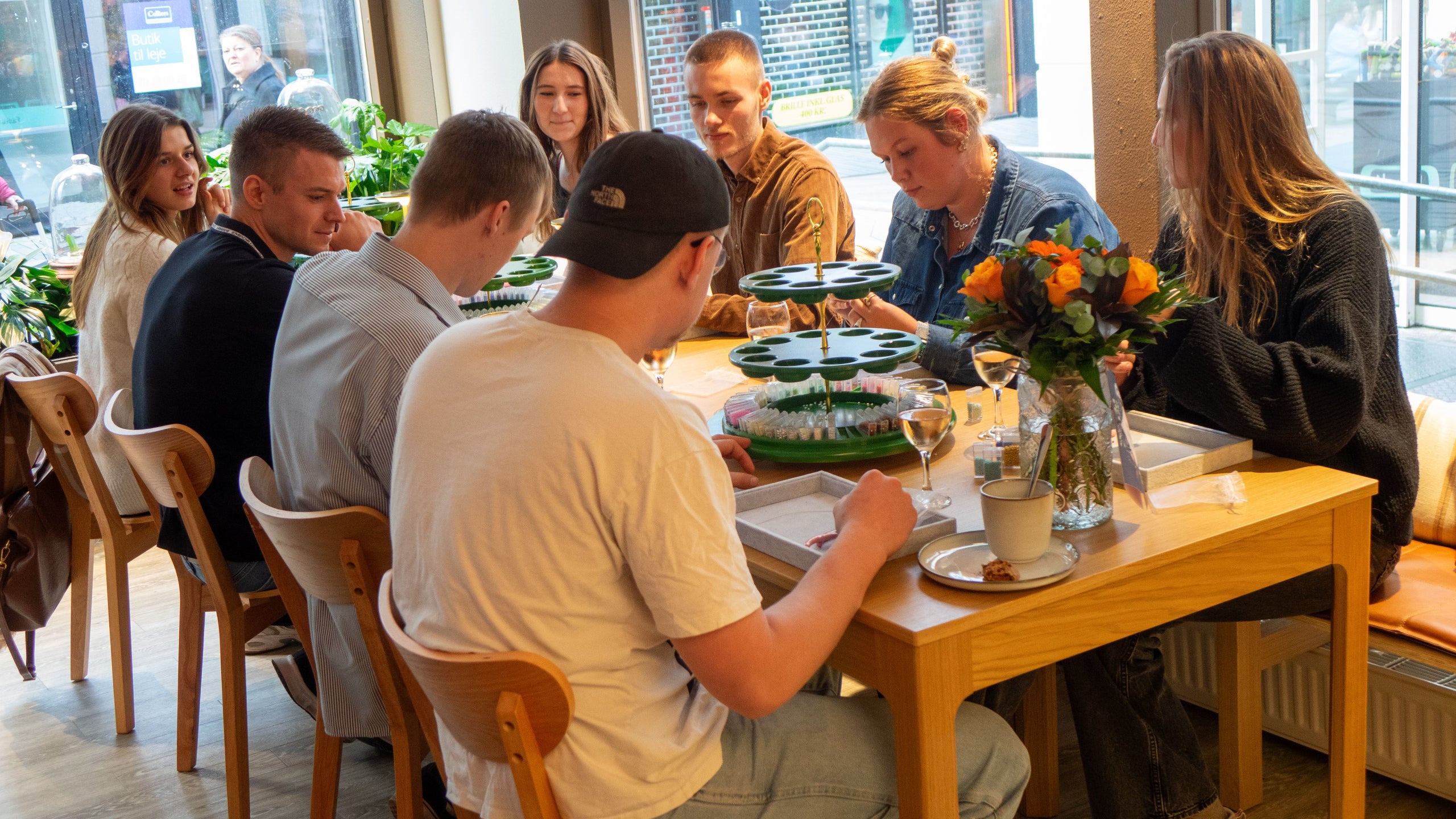 Deltagere, mænd og kvinder, laver deres egne smykker til en workshop hos Smyk og Hyg