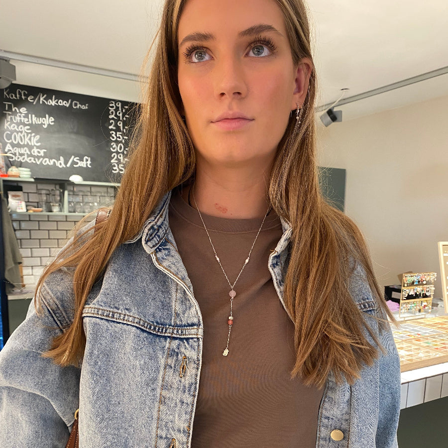Kvinde bærer hjemmelavet y-halskæde designet i smykkecafé hos Smyk&Hyg i Vejle