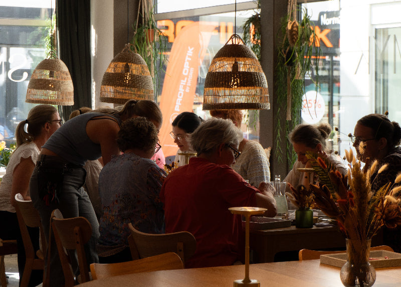 En gruppe kollegaer sidder og laver smykker