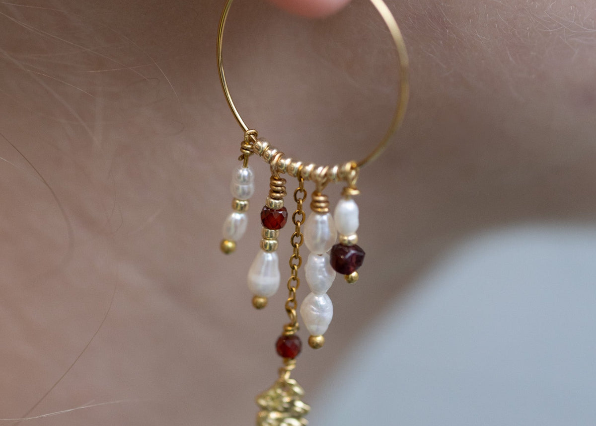 Nærbillede af ørering med perler og vedhæng skabt ved omsmykning hos Smyk&Hyg i Vejle, hvor gamle smykker upcycles og får nyt liv til Omsmykningssøndag.