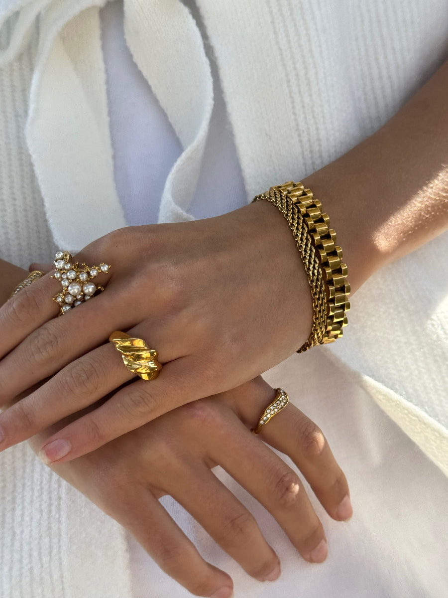 Hænder med vandfaste forgyldte armbånd og ringe fra Bay by Aqua Dulce – vandfaste smykker stylet hos Smyk&Hyg i Vejle