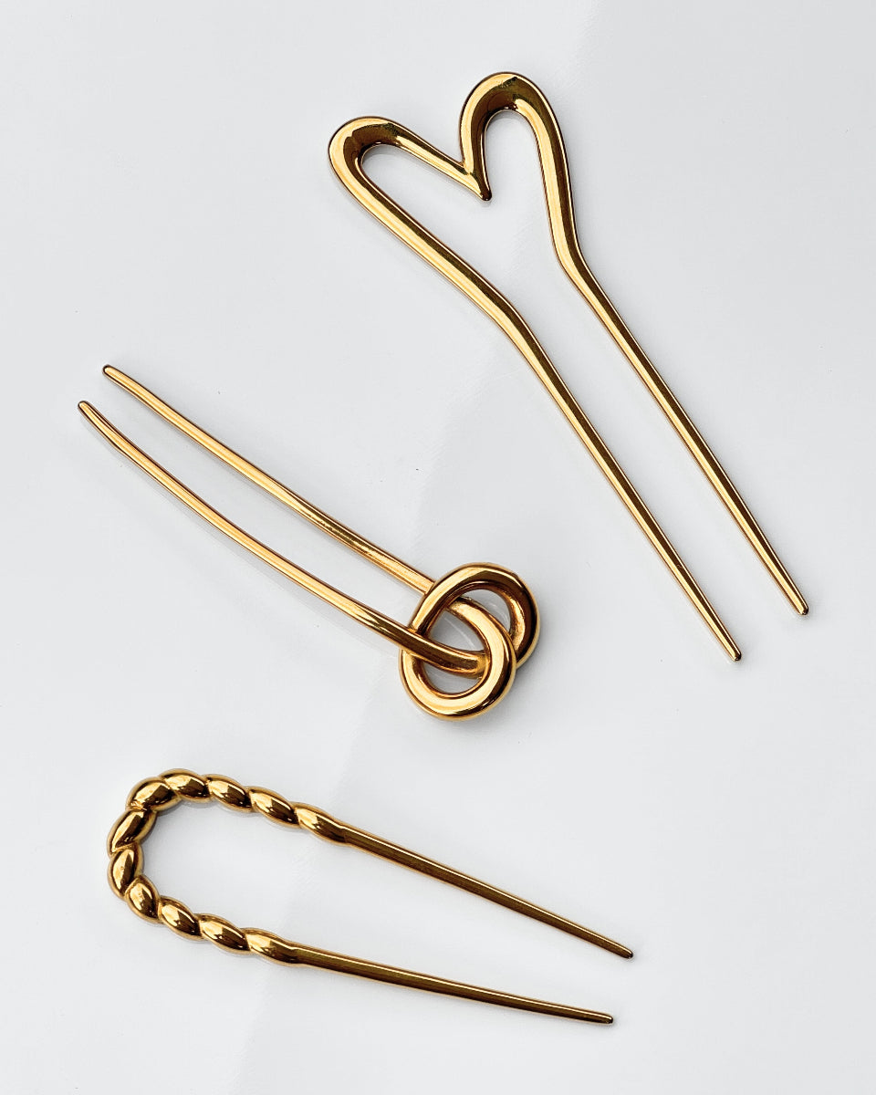 Guldfarvede hårnåle fra Bay by Aqua Dulce i vandfast design – stilfulde håraccessories hos Smyk&Hyg i Vejle
